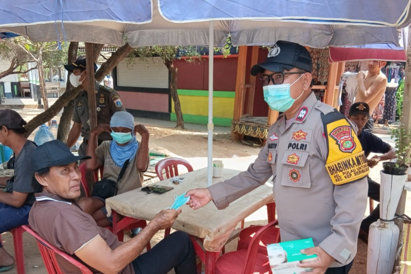 Jaga Jakarta di Pulau Untung Jawa, Bhabinkamtibmas Sosialisasikan Polisi 110 dan Bagikan Masker