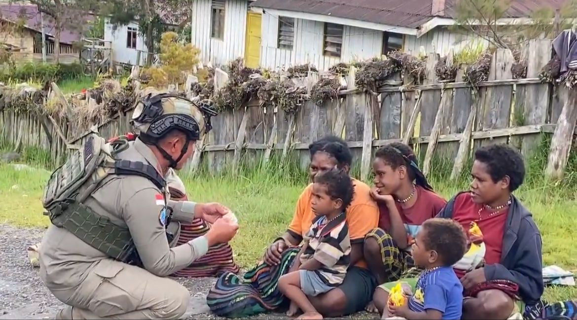 Sentuhan Humanis Satgas Damai Cartenz di Sinak Dengan Bagikan Makanan Ringan kepada Warga