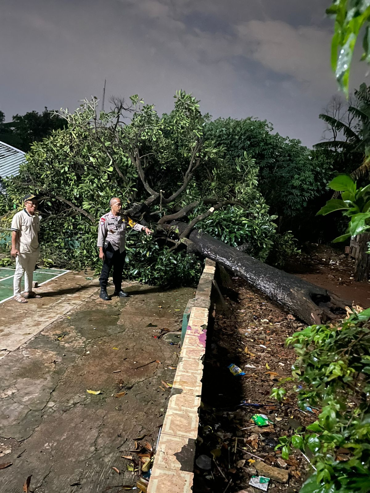 Bhabinkamtibmas Jaticempaka Sigap Evakuasi Pohon Tumbang Timpa Pos Ronda